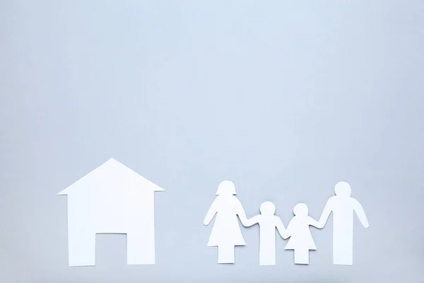 Figure di famiglia di carta e casa su sfondo grigio — Foto Stock