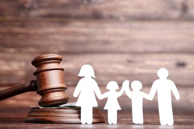 Family figures with gavel on brown wooden table clipart
