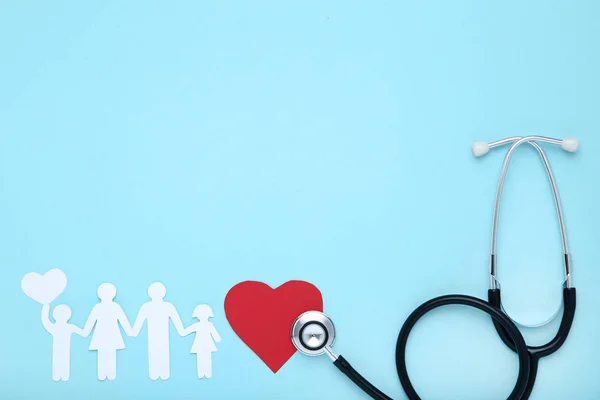 Family figures with red heart and stethoscope on blue background — Stock Photo, Image