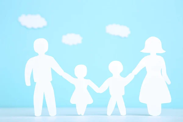 Figure di famiglia di carta con nuvole su sfondo blu — Foto Stock