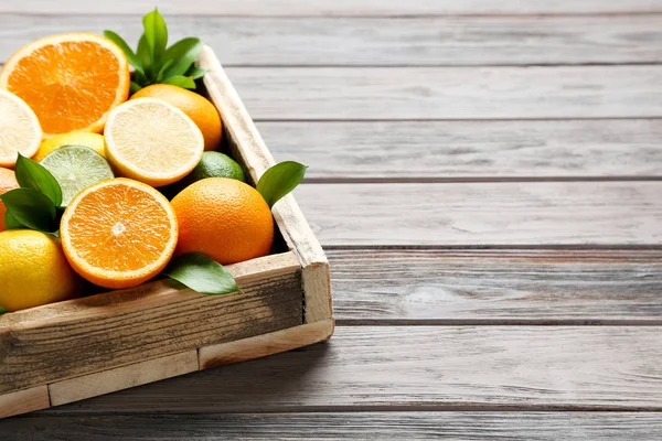 Citrus fruits in crate on wooden table — Stock Photo, Image