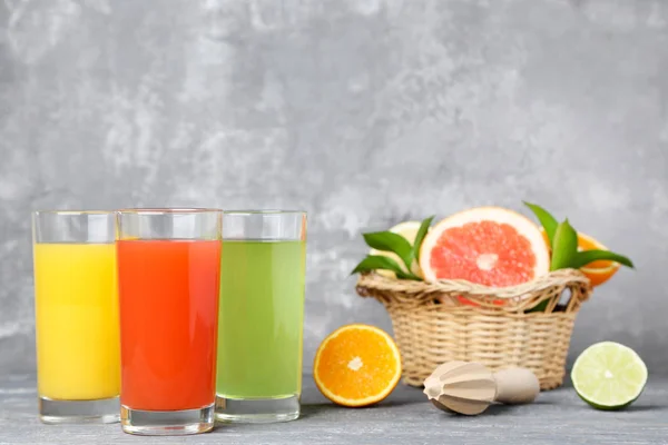 Citrus juice in glasses with fruits on wooden table — Stock Photo, Image