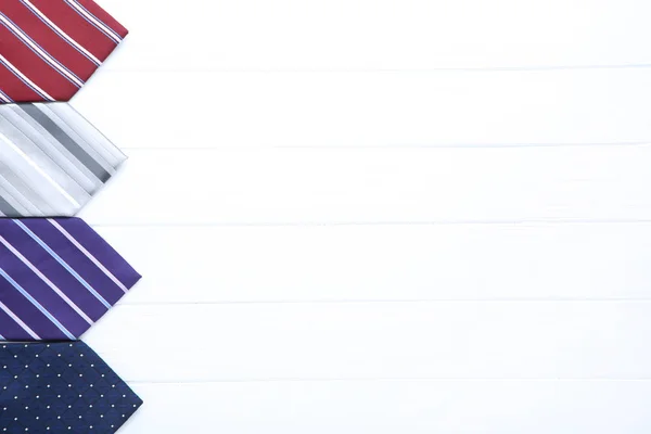 Corbatas de colores sobre mesa de madera blanca — Foto de Stock