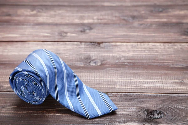 Striped necktie on brown wooden table — Stock Photo, Image