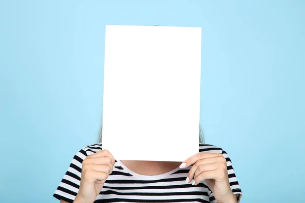 Jovem segurando placa branca em branco no fundo azul — Fotografia de Stock