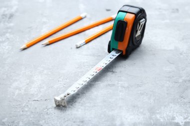 Gri ahşap masa üzerinde kalemler ile Inşaat ruleti