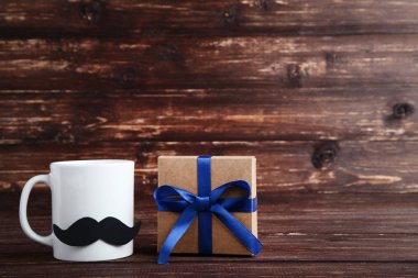 Kağıt bıyıklı beyaz kupa ve hediye kutusu. Patron gün kavramı