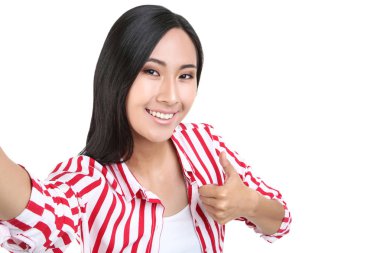 Selfie çeken ve başparmağını beyaz sırta gösteren güzel kadın