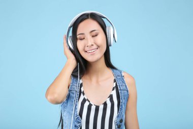 Mavi arka planda kulaklıklı güzel kadın