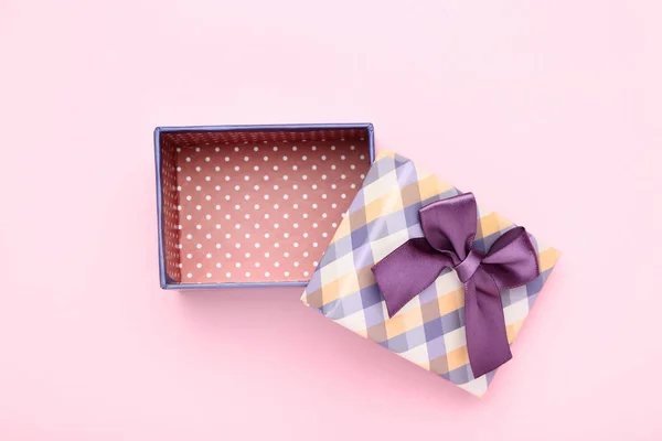 Open gift box with purple bow on pink background — Stock Photo, Image