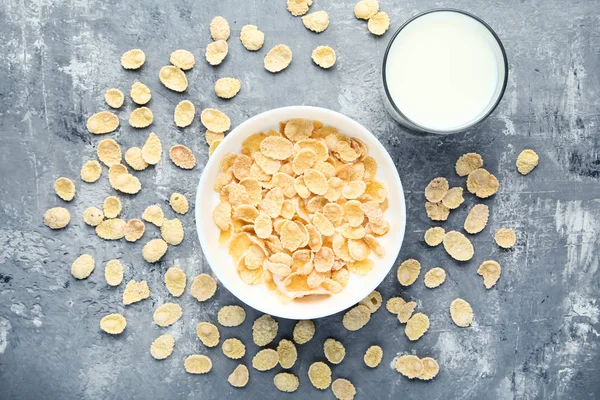 Copos de maíz con vaso de leche sobre mesa de madera gris — Foto de Stock