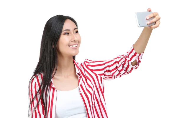 Mujer joven haciendo selfie en el teléfono inteligente sobre fondo blanco —  Fotos de Stock