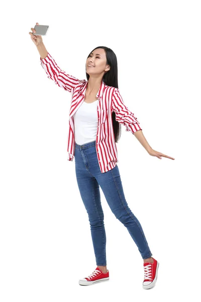 Mujer joven haciendo selfie en el teléfono inteligente sobre fondo blanco —  Fotos de Stock