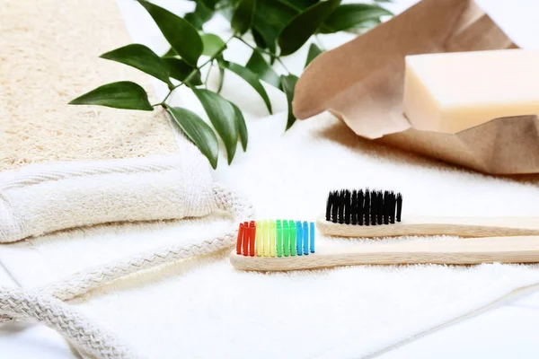 Bamboo toothbrushes with towel, soap and green leafs — Stock Photo, Image