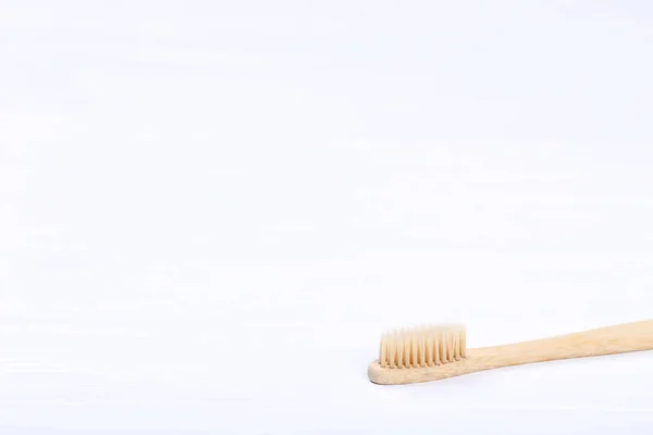Бамбуковая зубная щетка на белом деревянном столе — стоковое фото