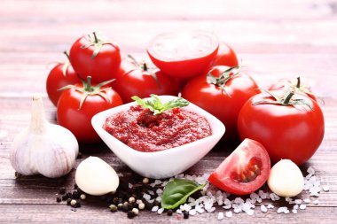 Ketçap baharat ve sarımsak kahverengi ahşap masa üzerinde kase