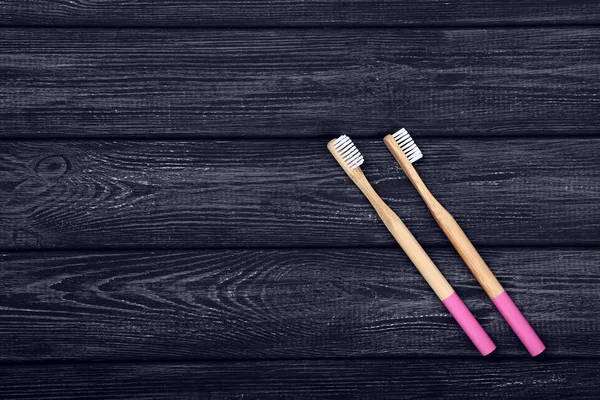 Bamboe tandenborstels op zwarte houten tafel — Stockfoto