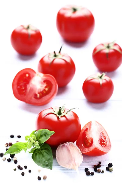 Tomates maduros con hojas de albahaca y ajo sobre mesa de madera —  Fotos de Stock