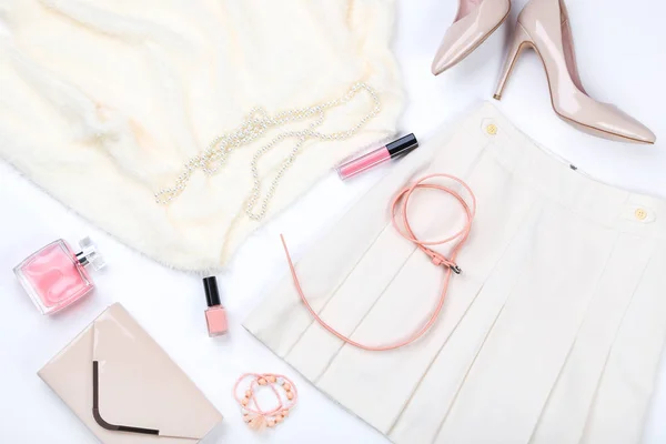 Elegante ropa de mujer con perfume y cosméticos en la espalda blanca —  Fotos de Stock