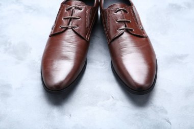 Gri arka planda erkek deri ayakkabılar