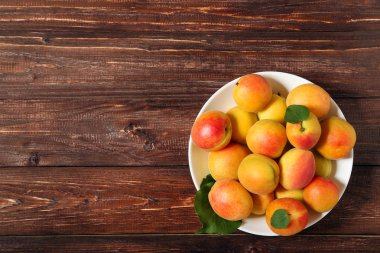 Kahverengi ahşap masa üzerinde tabak tabaktatlı kayısı