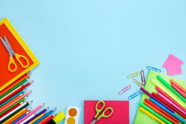 Mavi arka planda farklı okul malzemeleri var.