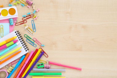 Okul malzemeleri kahverengi ahşap masada.