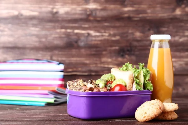 Σχολικό κουτί μεσημεριανού γεύματος με σάντουιτς και ξηρούς καρπούς σε ξύλινο τραπέζι — Φωτογραφία Αρχείου