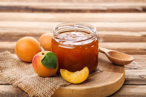 Confiture en pot et abricots sur table en bois marron — Photo