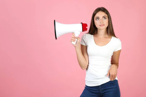 Mujer joven con megáfono sobre fondo rosa — Foto de Stock