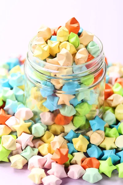 Kleurrijke papier sterren in glazen pot — Stockfoto