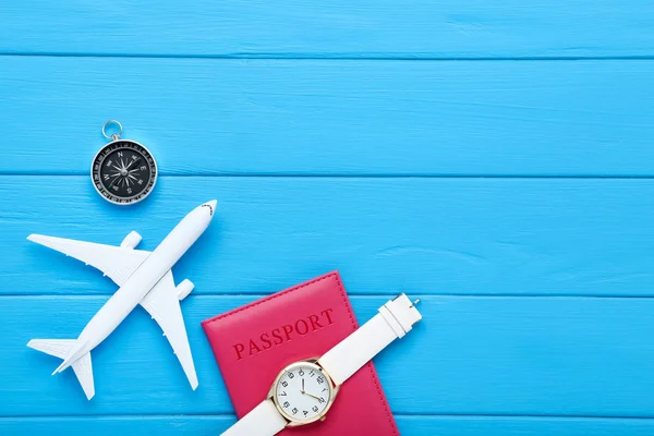 Flugzeugmodell mit Pass, Armbanduhr und Kompass auf blauem — Stockfoto