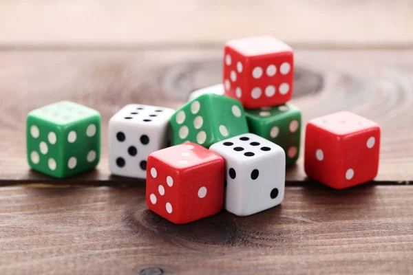 Colourful dice on brown wooden table — Stock Photo, Image