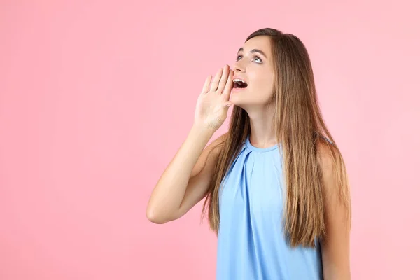 Ung kvinna i blå klänning skriker på rosa bakgrund — Stockfoto