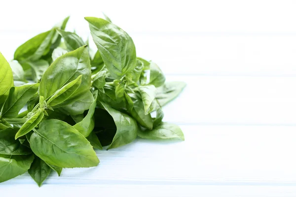 Green basil leafs on wooden table — Stock Photo, Image