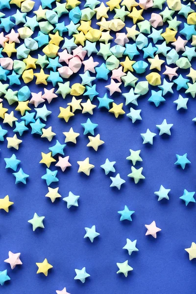 Färgglada pappers stjärnor på blå bakgrund — Stockfoto