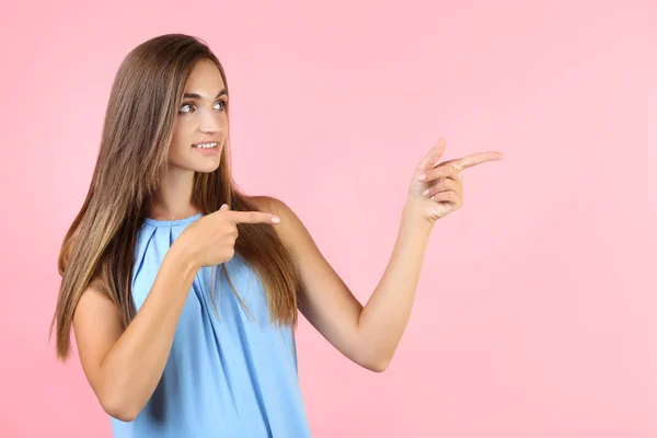 Jonge vrouw in blauwe jurk op roze achtergrond — Stockfoto