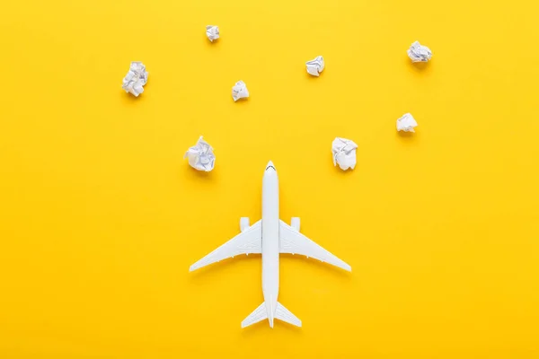 Modelo de avião com nuvens de papel sobre fundo amarelo — Fotografia de Stock