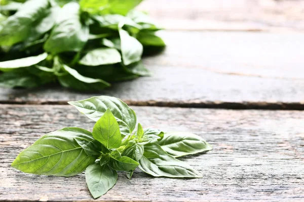 Grön basilika blad på grå träbord — Stockfoto