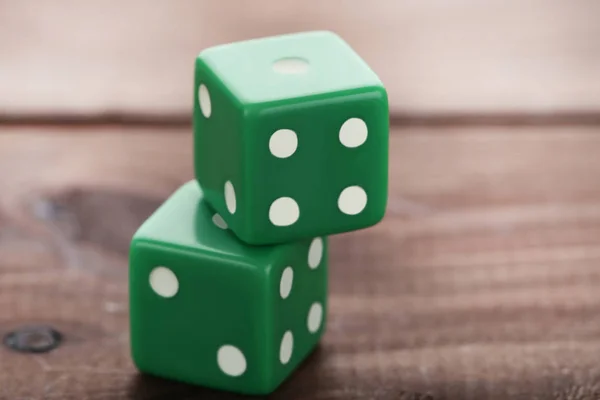 Dados verdes sobre mesa de madera marrón — Foto de Stock