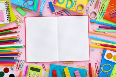 Pembe backgroun açık defter ile farklı okul malzemeleri