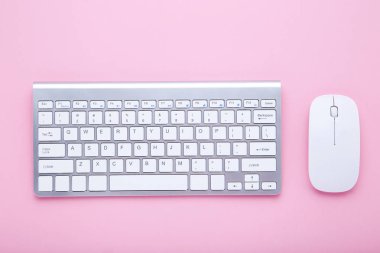 Pembe arka planda bilgisayar klavyesi ve fare