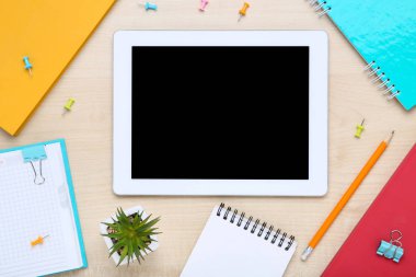 Kahverengi ahşap masa üzerinde ofis malzemeleri ile Tablet bilgisayar