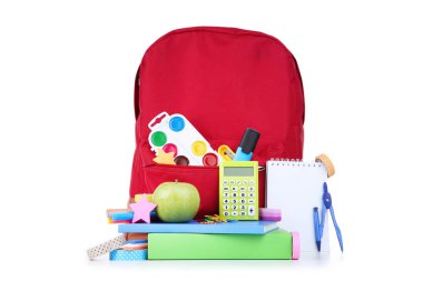 Beyaz arka planda kırmızı sırt çantası ile okul malzemeleri