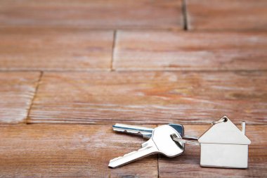 Kahverengi ahşap masa üzerinde ev sembolü ile gümüş tuşları