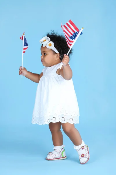 Hermosa niña con banderas americanas sobre fondo azul — Foto de Stock