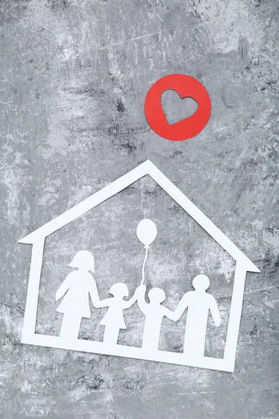 Figure di famiglia e casa con cuore rosso su sfondo grigio — Foto Stock