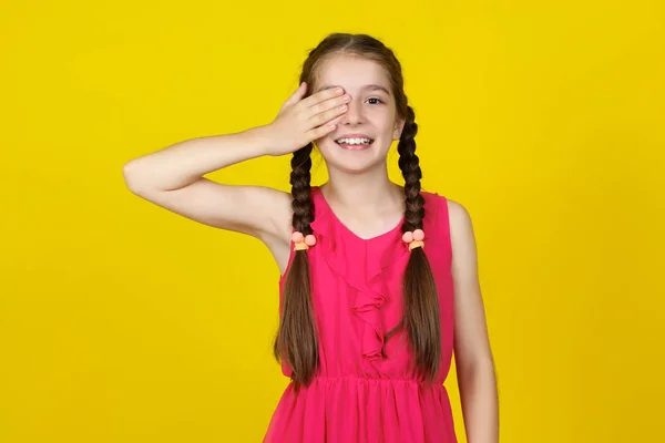 Krásná mladá dívka v růžových šatech na žlutém pozadí — Stock fotografie