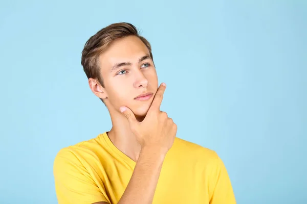 Porträtt av ung man i gul t-shirt på blå bakgrund — Stockfoto