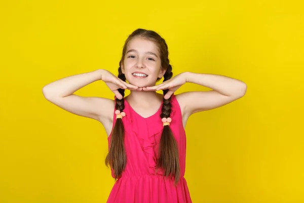 Beautiful young girl in pink dress on yellow background — Stock Photo, Image
